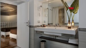 A modern bathroom with a large mirror, two hair dryers, a sink, and a trash can. - DVE Suite Rome (Rome)