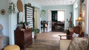 Ein gemütliches Wohnzimmer mit einer Holzkommode, einer Couch und einem Essbereich mit Tisch und Stühlen.