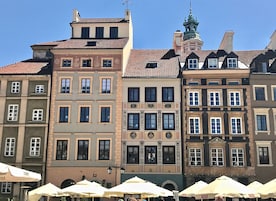 A row of historic buildings with uniform window patterns and a central building with ornate decorations.