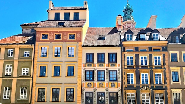 Una hilera de edificios históricos coloridos con estilos arquitectónicos distintos, que incluyen fachadas ornamentadas y diseños de ventanas variados.