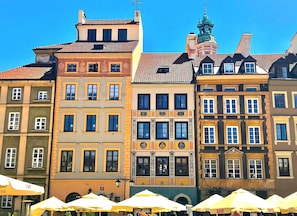 Une rangée de bâtiments historiques aux couleurs vives, chacun présentant un style architectural distinct, avec des façades richement décorées et des modèles de fenêtres variés.