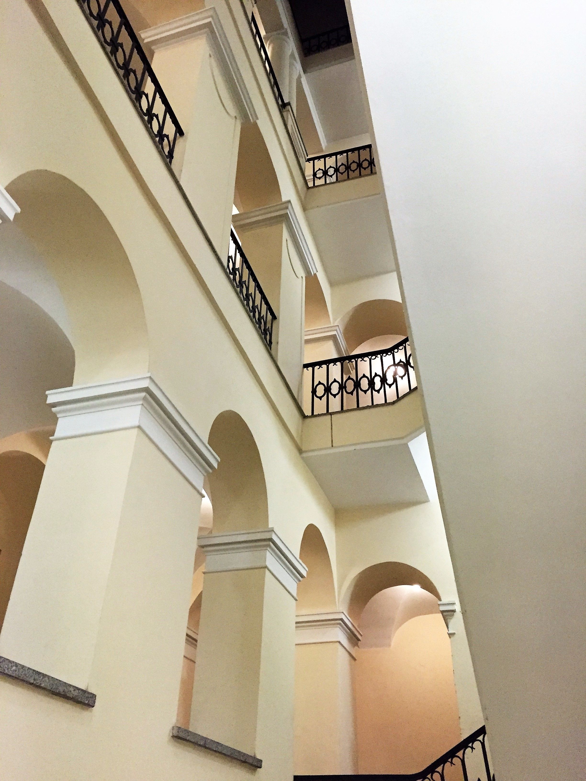 A multi-level interior with arched balconies and a central column.