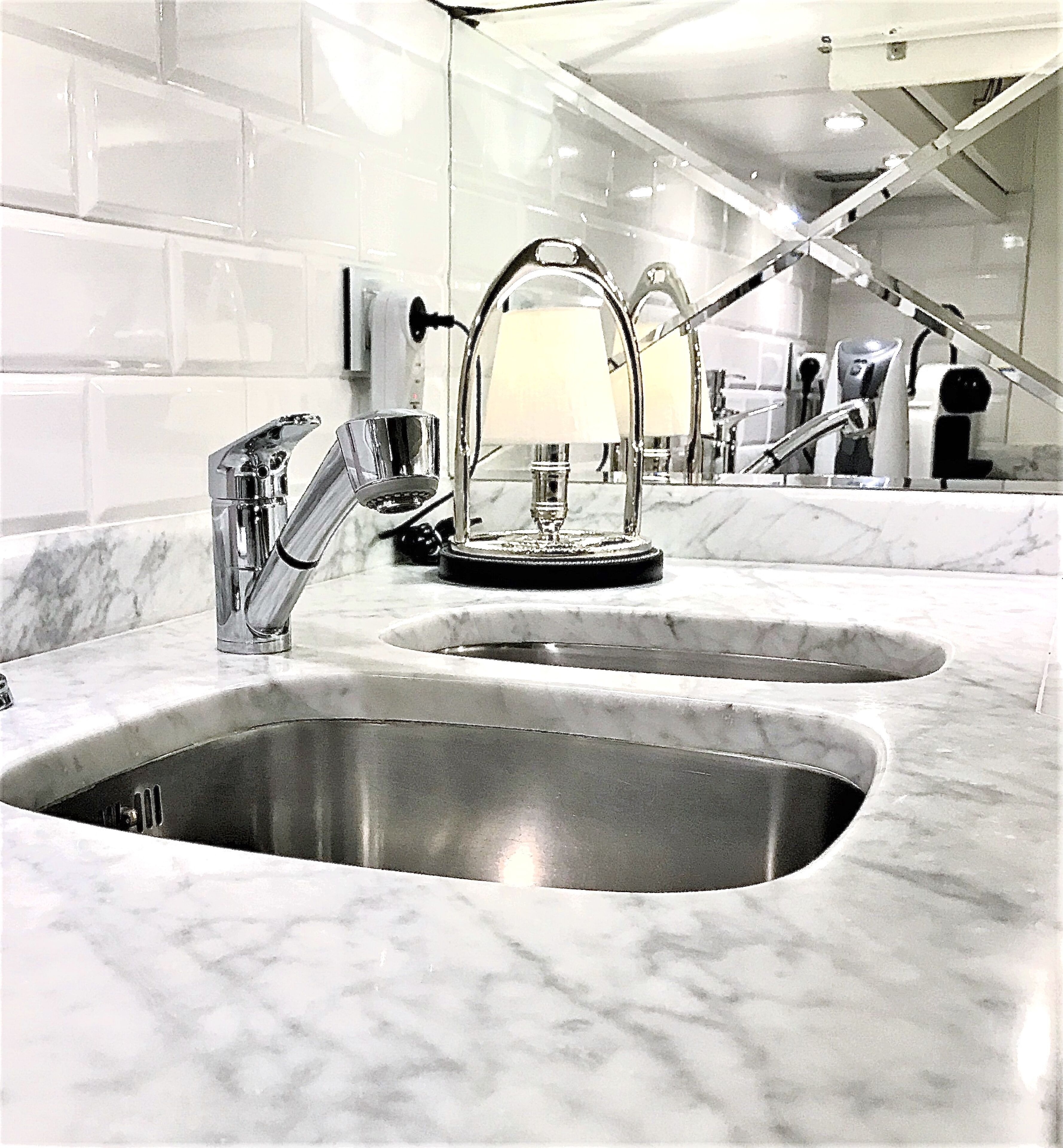 A modern bathroom with two sinks, a mirror, and a towel rack.