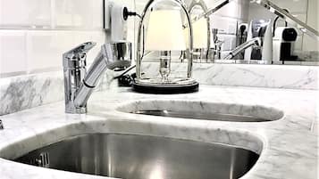 A modern bathroom with two sinks, a mirror, and a towel rack.