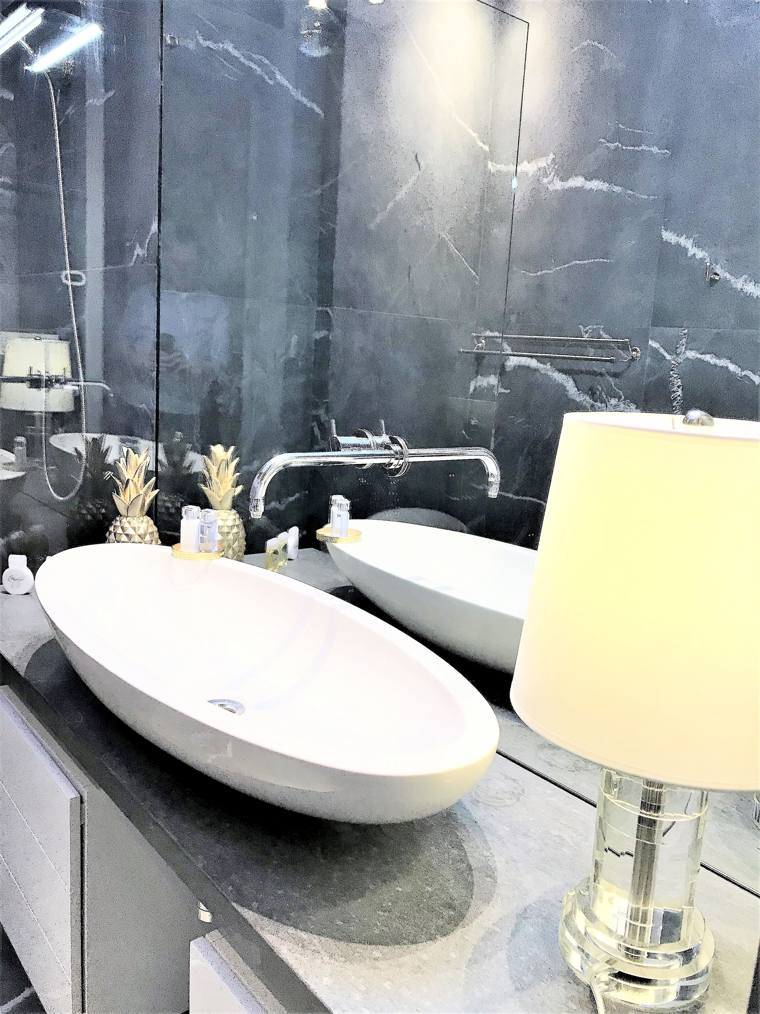 Une salle de bain avec deux lavabos, un miroir et une lampe.