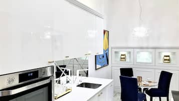 Una cocina moderna con horno empotrado, reloj digital y encimera blanca.