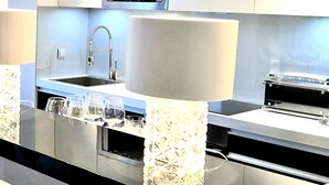Una cocina moderna con electrodomésticos de acero inoxidable, microondas integrado y encimera de granito.