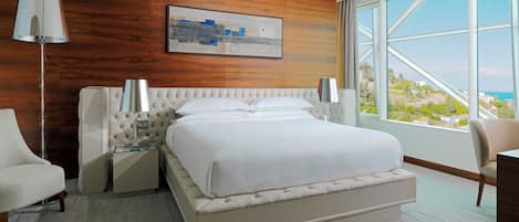 A modern hotel room with a large bed, a view of the city, and a wooden accent wall.