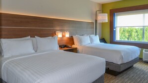 A hotel room with two beds, a nightstand with a lamp, and a window with a view of trees. - Holiday Inn Express & Suites Charlotte NE - University Area by IHG (Charlotte)