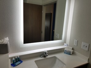 A bathroom with a large mirror, a sink, and a window. - Holiday Inn Express & Suites Charlotte NE - University Area by IHG (Charlotte)