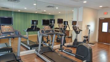 A gym with treadmills, elliptical machines, and stationary bikes.
