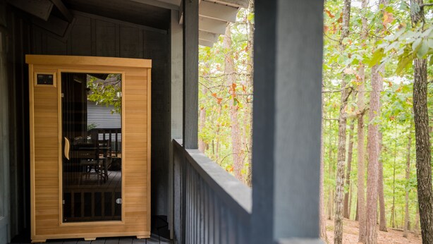 A wooden door with a glass panel, leading to a deck with a view of a forest. - Hogsveil Cottages - Harry Potter Themed (Eureka Springs)