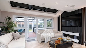 Una sala de estar moderna con un sofá, una mesa de centro de vidrio y una chimenea.