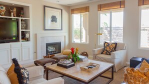 Una sala de estar con chimenea, televisión y mesa de centro.