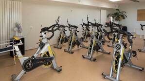 Een sportschool met meerdere hometrainers, netjes opgesteld in rijen.