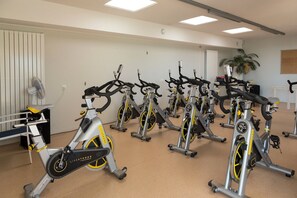 Ein Fitnessraum mit mehreren in Reihen angeordneten Ergometer.