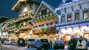 A traditional European building with multiple stories, decorated with festive lights and garlands. - La Cabina (Leavenworth)