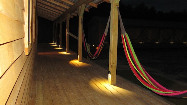A covered wooden deck with hammocks hanging from the beams. - Godspeed Events & Lodging (Port Matilda)