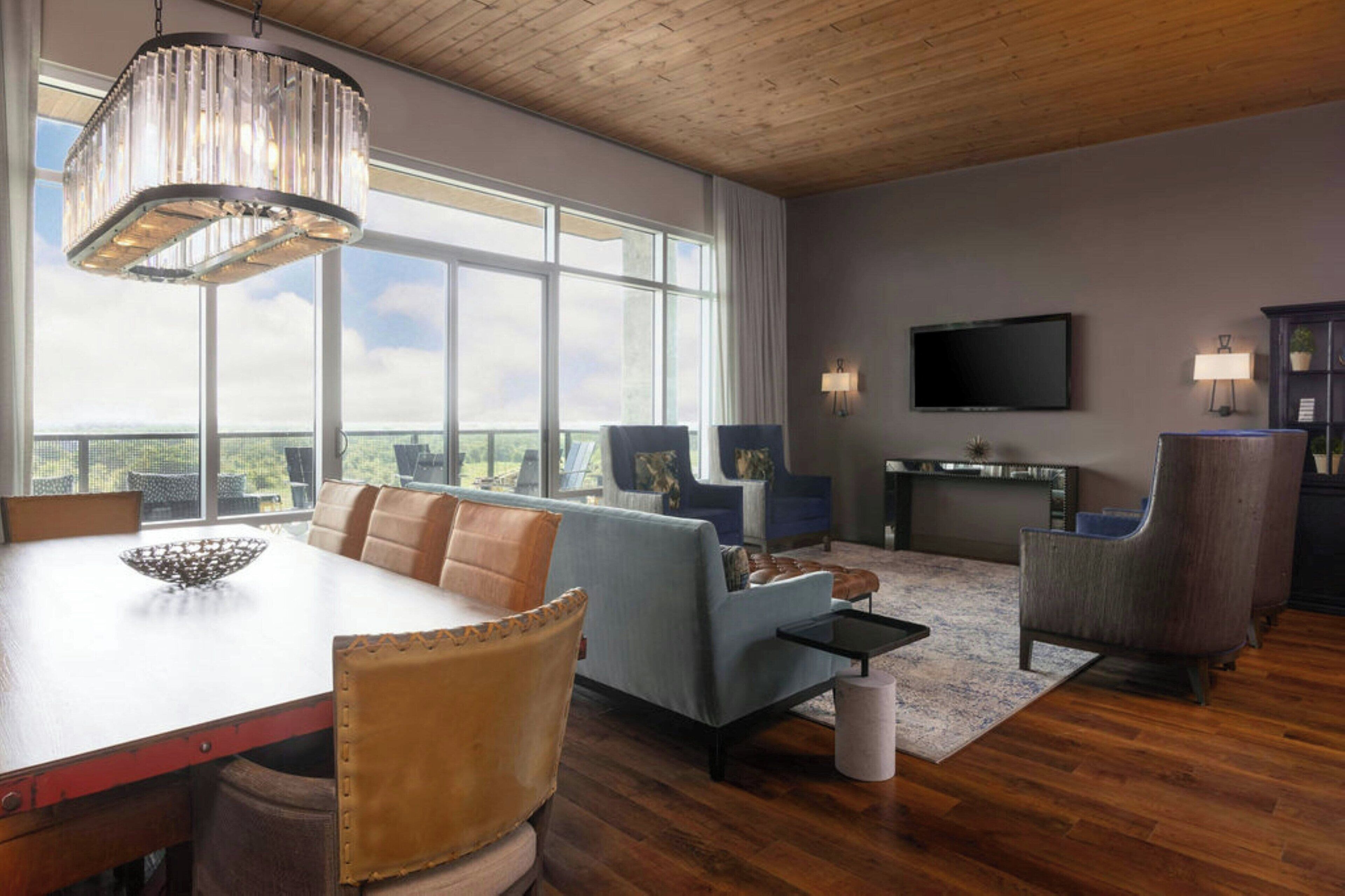 A spacious living room with a large window, a fireplace, and a television.