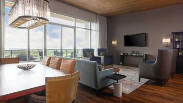 A spacious living room with a large window, a fireplace, and a television.