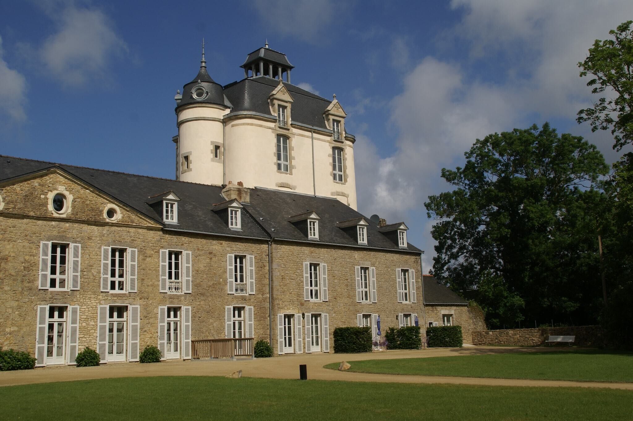A large stone building with multiple windows and a tower.