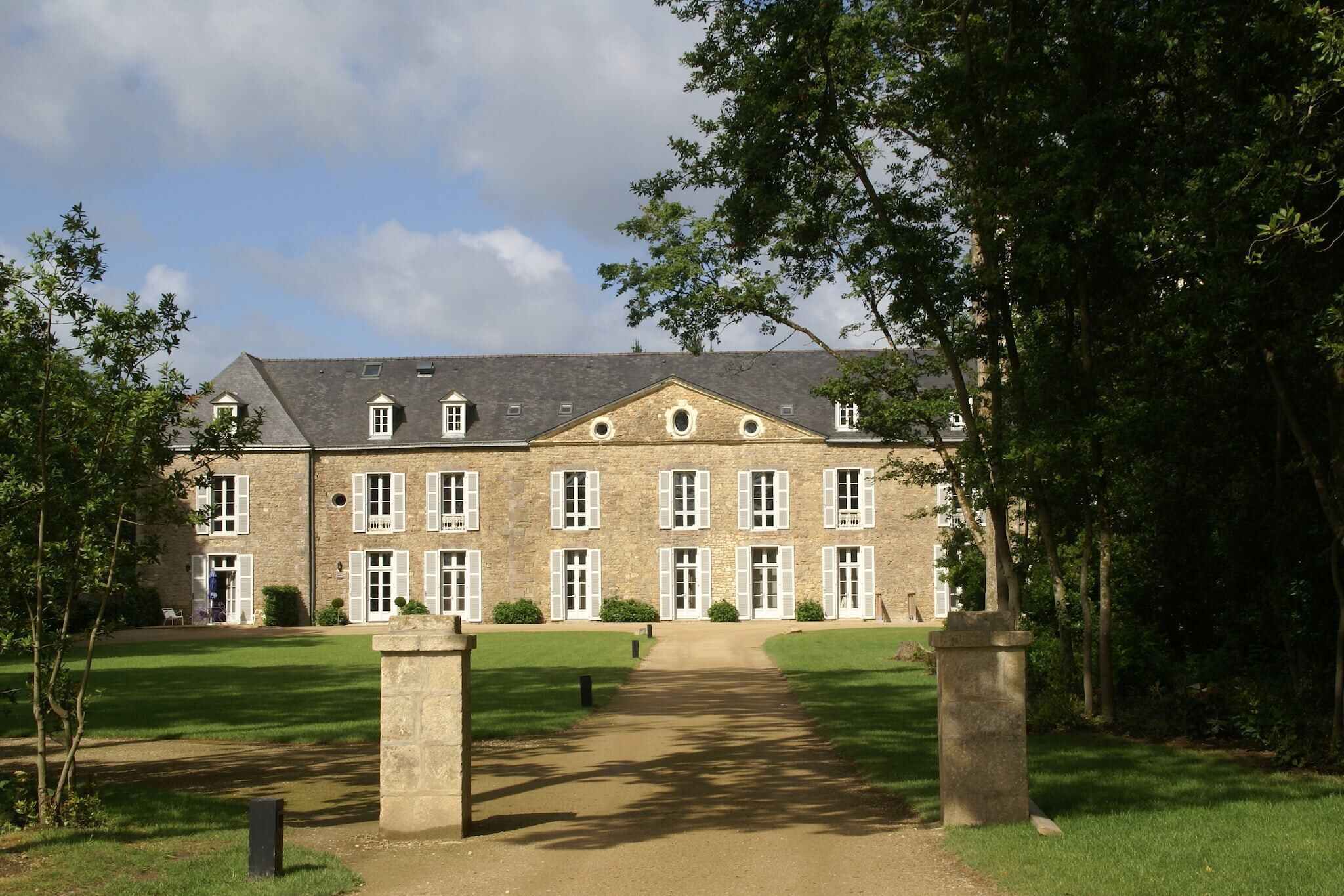 Un grand bâtiment en pierre doté de nombreuses fenêtres et d’une entrée centrale.