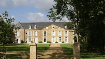 Un grand bâtiment en pierre doté de nombreuses fenêtres et d’une entrée centrale.