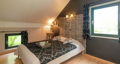 Maalaistyylinen lomamökki, jossa on sauna ja poreallas metsäisellä alueella