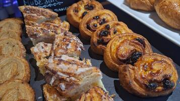 A display of various baked goods, including pastries and bread, arranged on a slate board.