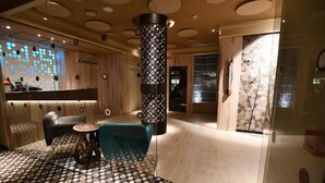 A modern interior with a patterned floor, a reception desk, and a large column.
