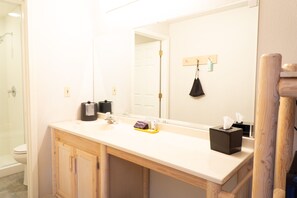 A bathroom with a white sink, a mirror, and a wooden cabinet.