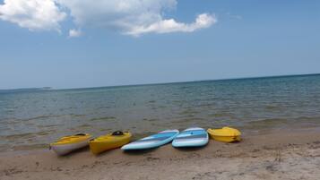 A beach with kayaks lined up on the sand.