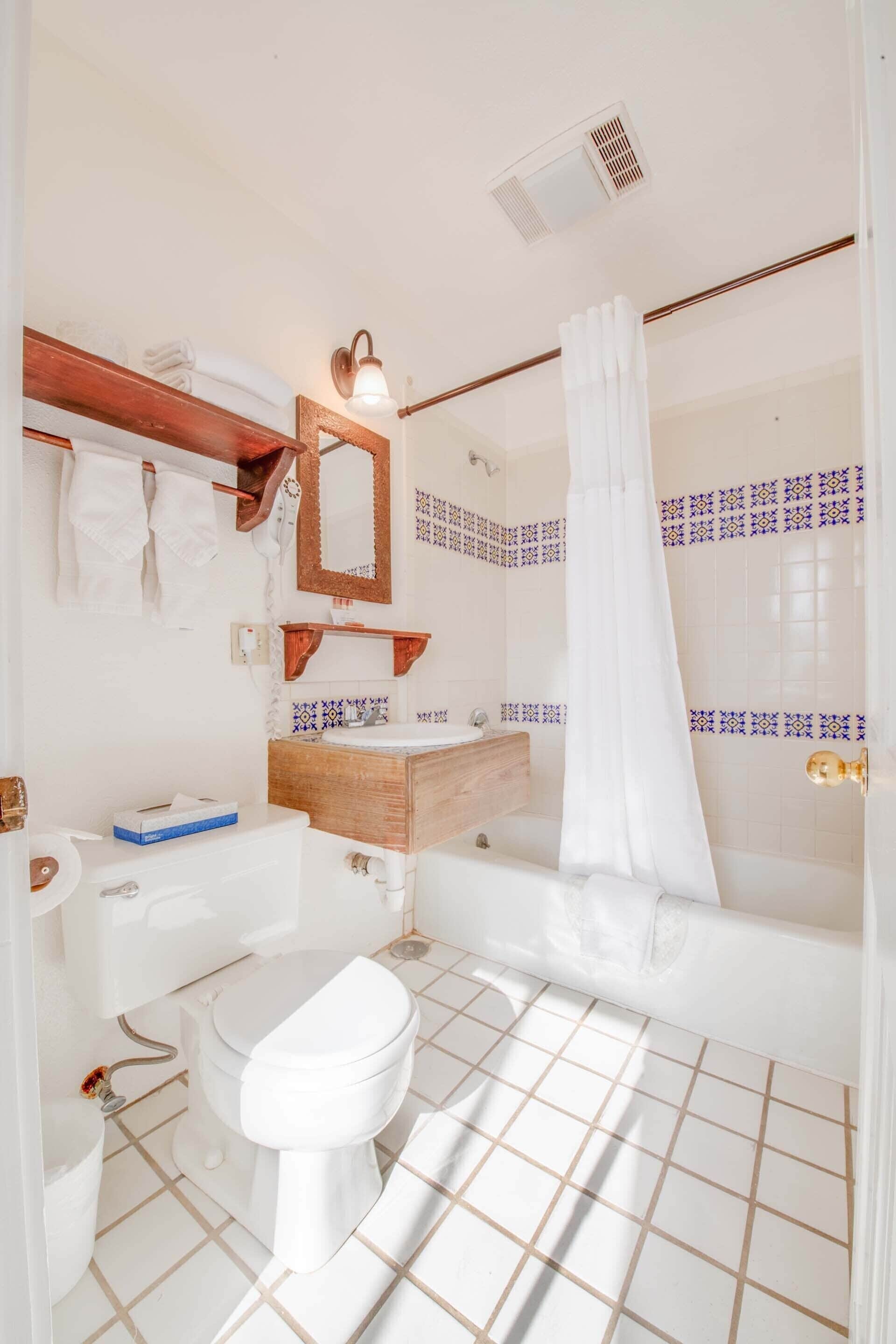 A bathroom with a toilet, sink, and bathtub.