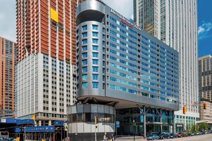A modern hotel with a curved facade, large windows, and a prominent entrance.