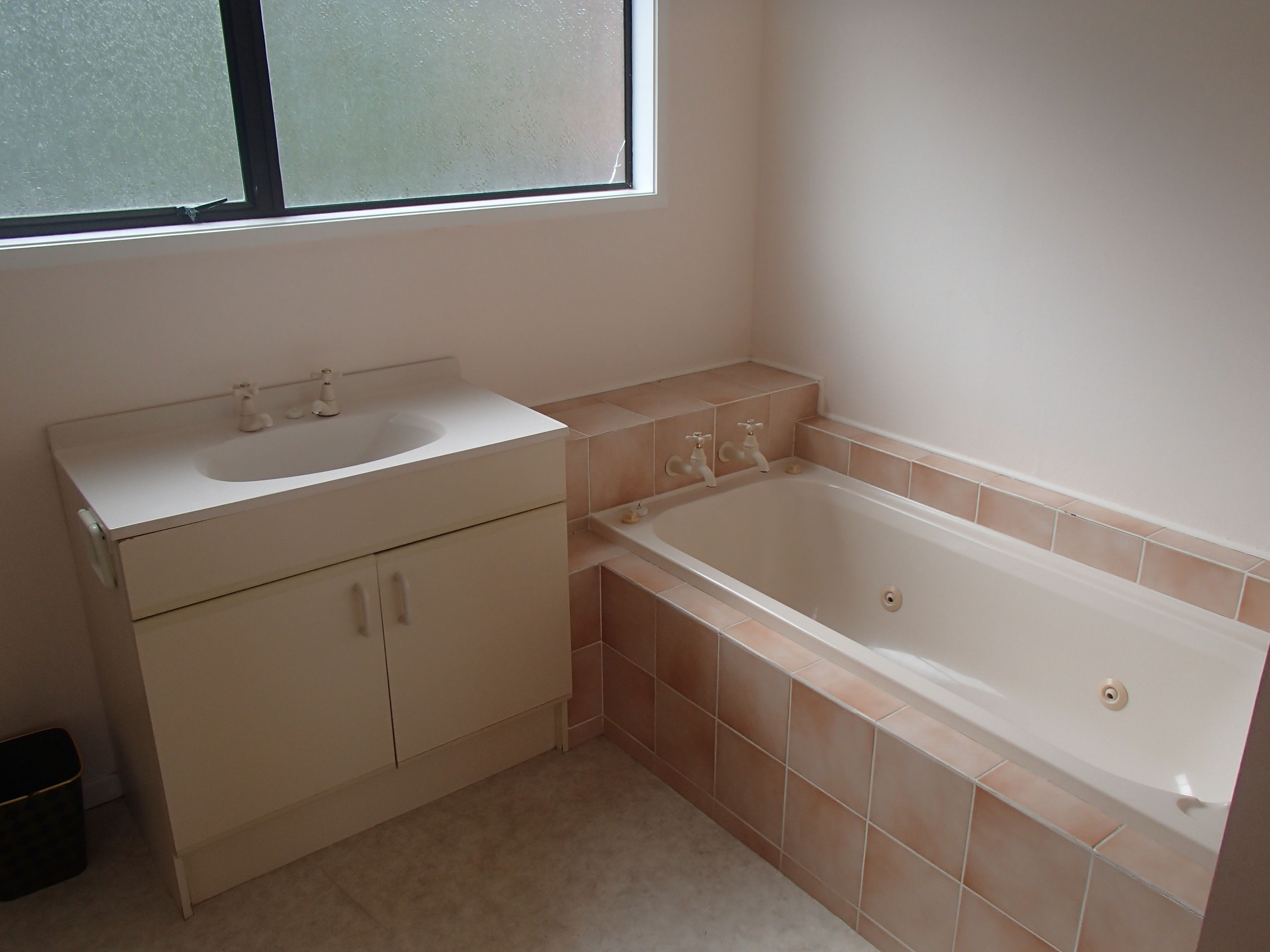Un baño con lavamanos, tocador y bañera.