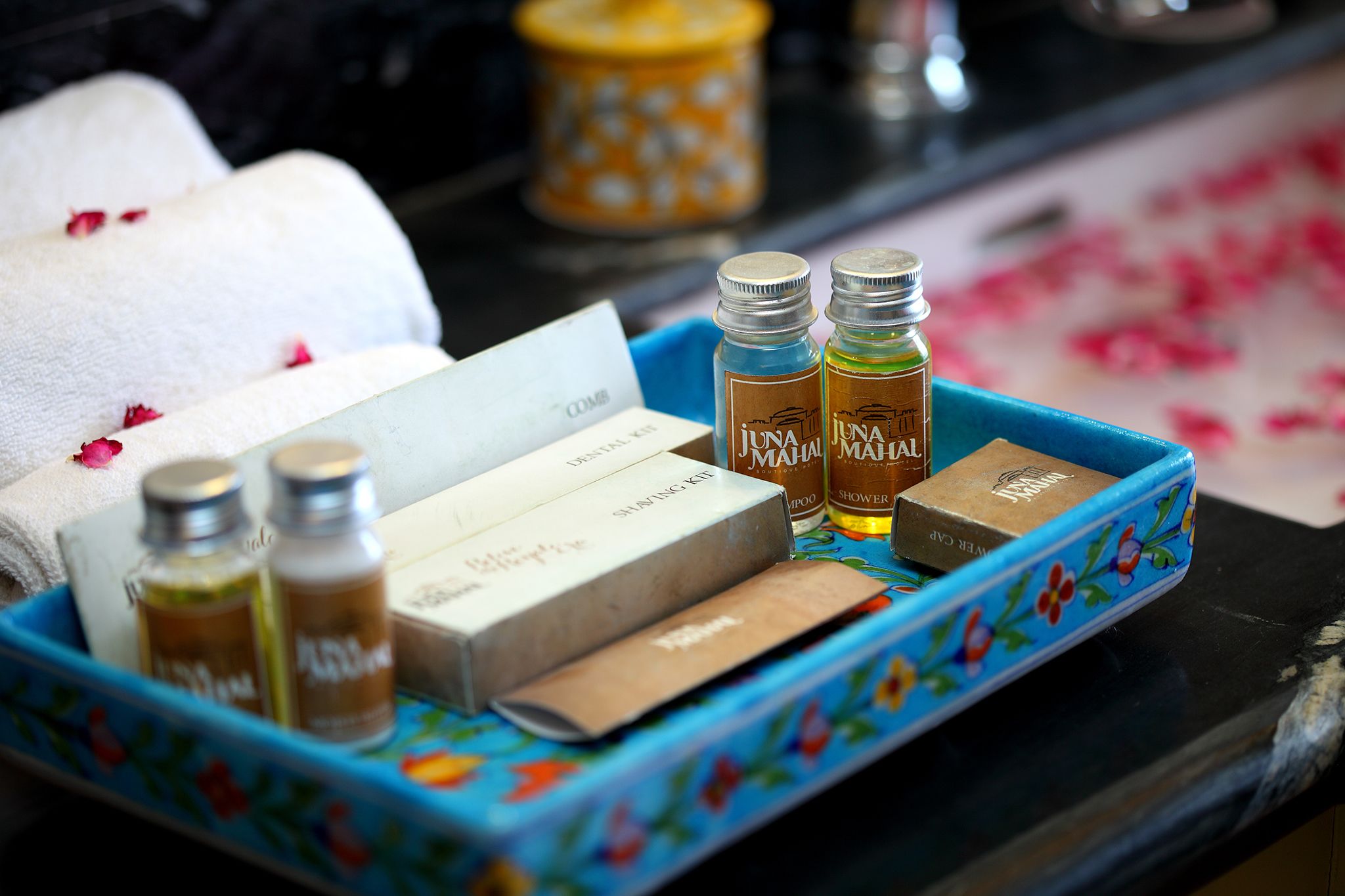Un plateau contenant des articles de toilette, notamment un kit de rasage, du shampoing et du gel douche.