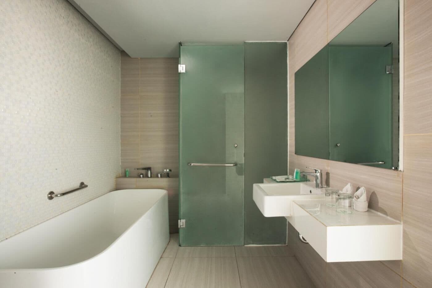 Un baño moderno con una bañera independiente, cabina de ducha con mampara de cristal y tocador con espejo.