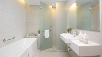 A modern bathroom with a bathtub, a glass shower enclosure, and a vanity with a mirror.