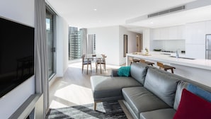 Un apartament modern amb zona de estar, menjador i cuina.