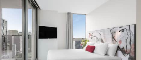 A modern hotel room with a large bed, a flat-screen TV, a city view, and a large abstract painting on the wall.