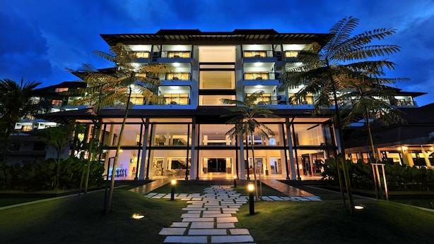 A multi-story hotel with a modern design, featuring a central entrance, glass facade, and outdoor seating area. - Sand & Sandals Desaru Beach Resort & Spa (Bandar Penawar)