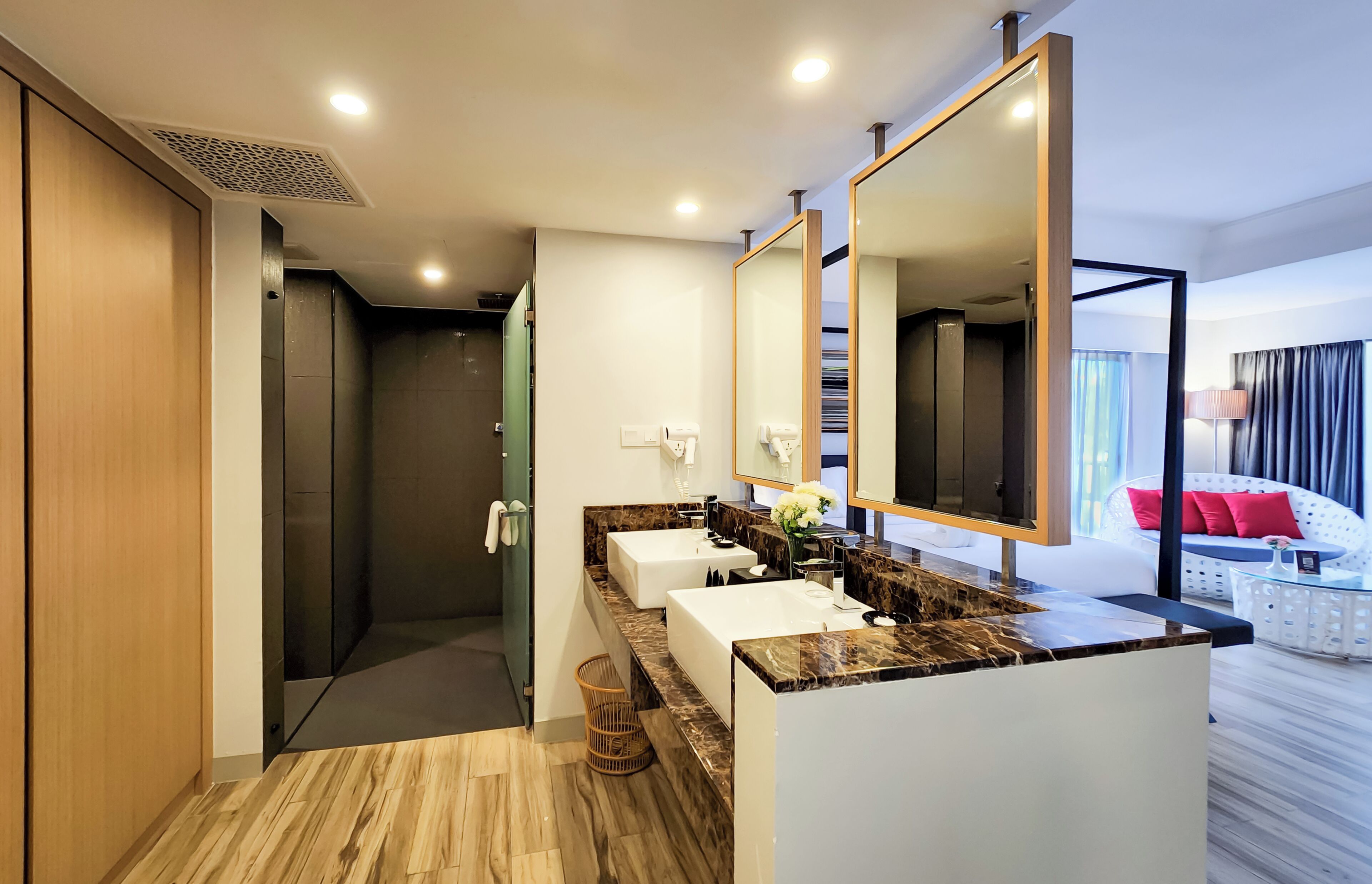 A modern bathroom with a vanity, mirrors, and a shower area.