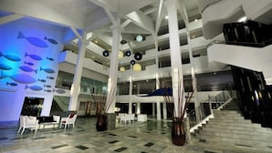 A spacious lobby with a high ceiling, multiple floors, and a staircase. - Sand & Sandals Desaru Beach Resort & Spa (Bandar Penawar)
