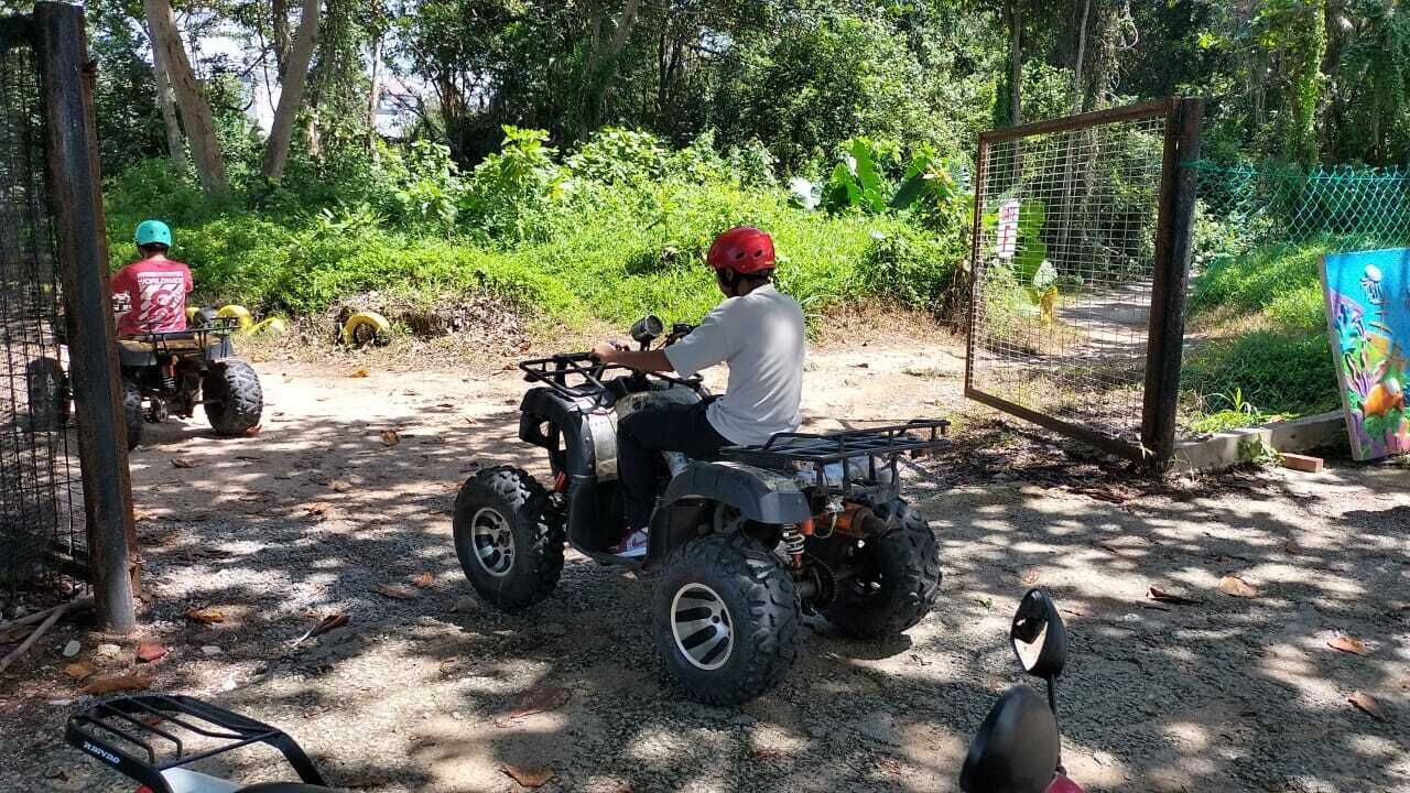 Een onverharde pad met twee quads aan de zijkant.