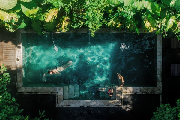 Una piscina al aire libre, sillones reclinables de piscina