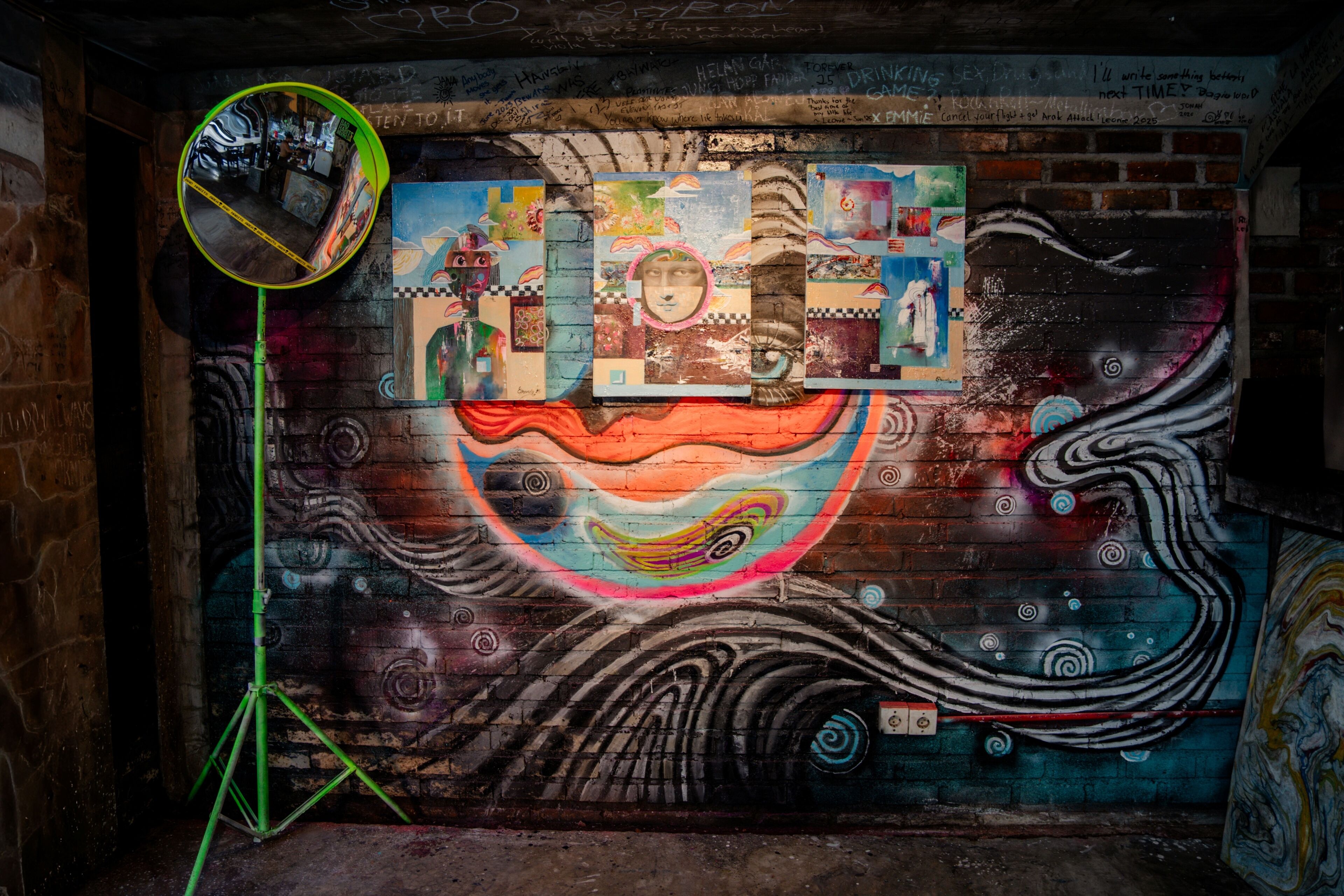 A mural with abstract and colorful designs on a brick wall.