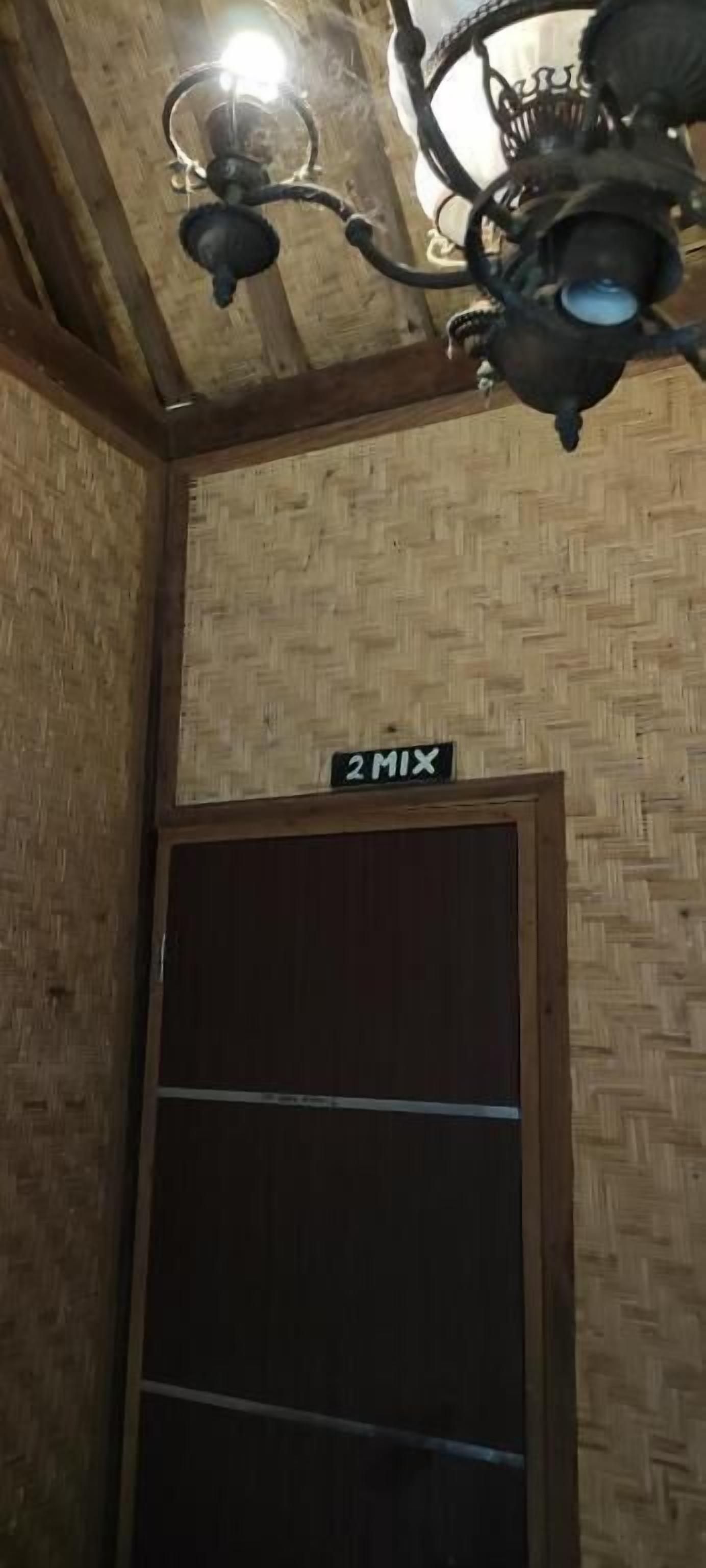 Habitación con un diseño trenzado en la pared, una puerta de madera y un letrero que dice "2MIX".