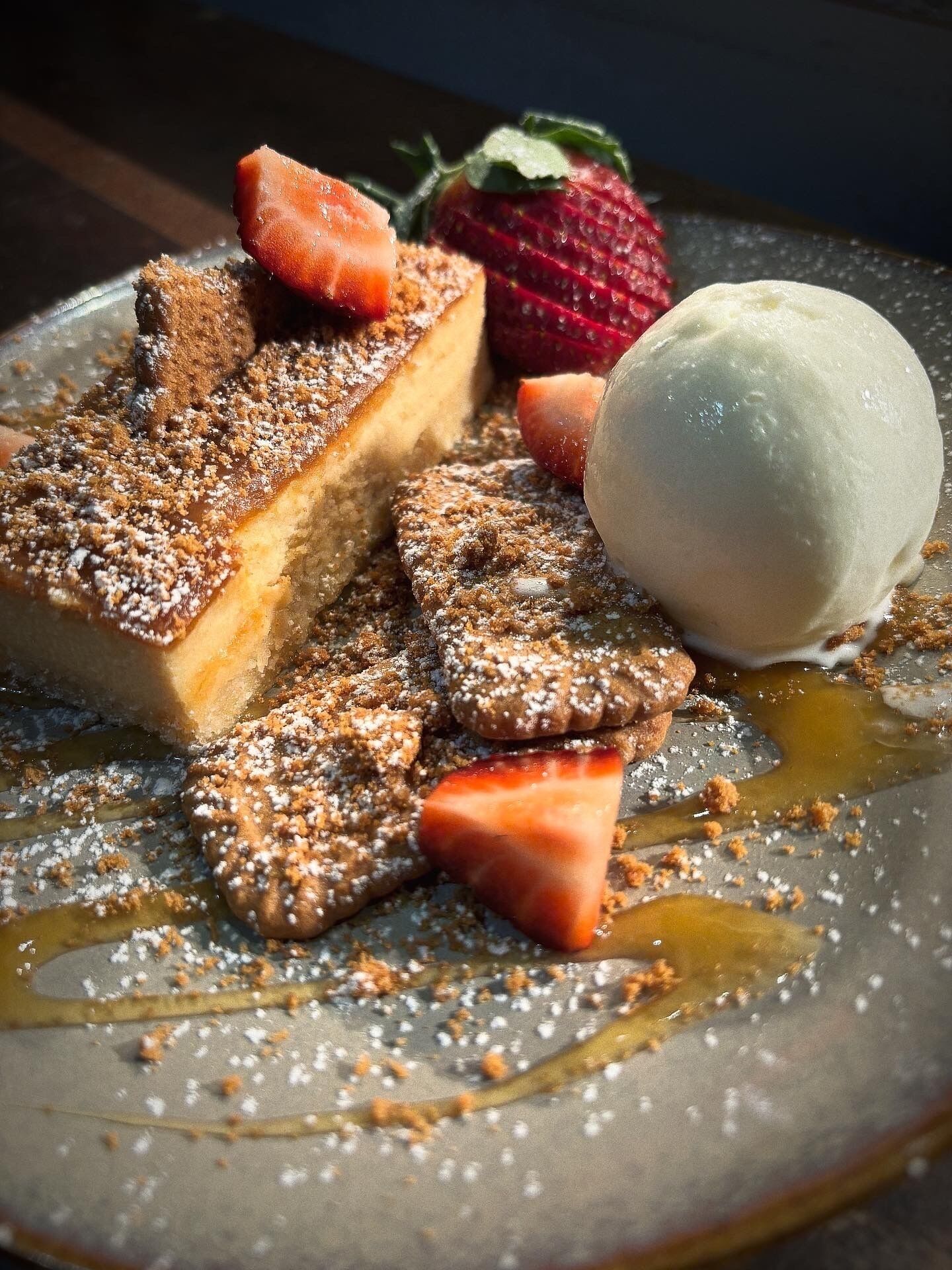 A dessert plate with a slice of cake, a scoop of ice cream, and strawberries.