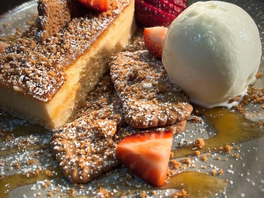 A dessert plate with a slice of cake, a scoop of ice cream, and strawberries.
