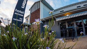 Een hotel met een bord, een restaurant en een gebouw met een modern ontwerp.
